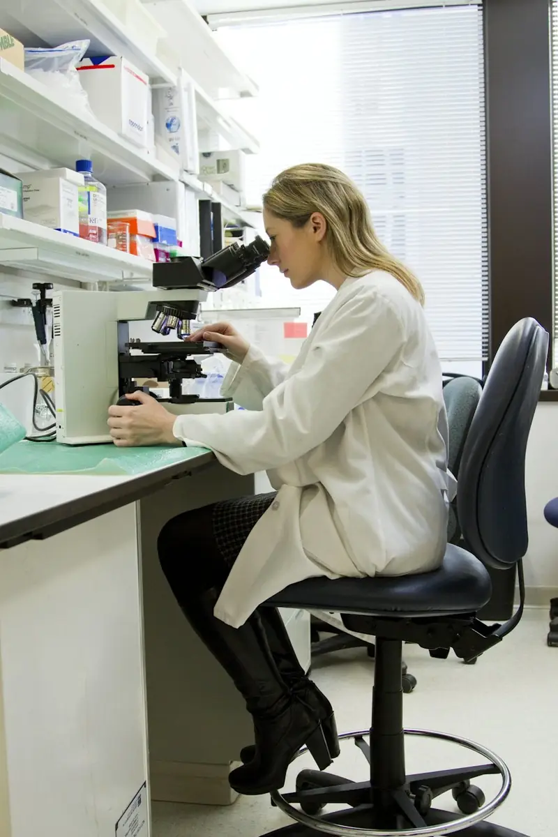 Lab scientist at a microscope